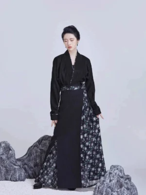 All-black Song Dynasty modern Hanfu outfit with cross-collar top, black pleated skirt, floral side panel, and decorative waist sash shown from the front