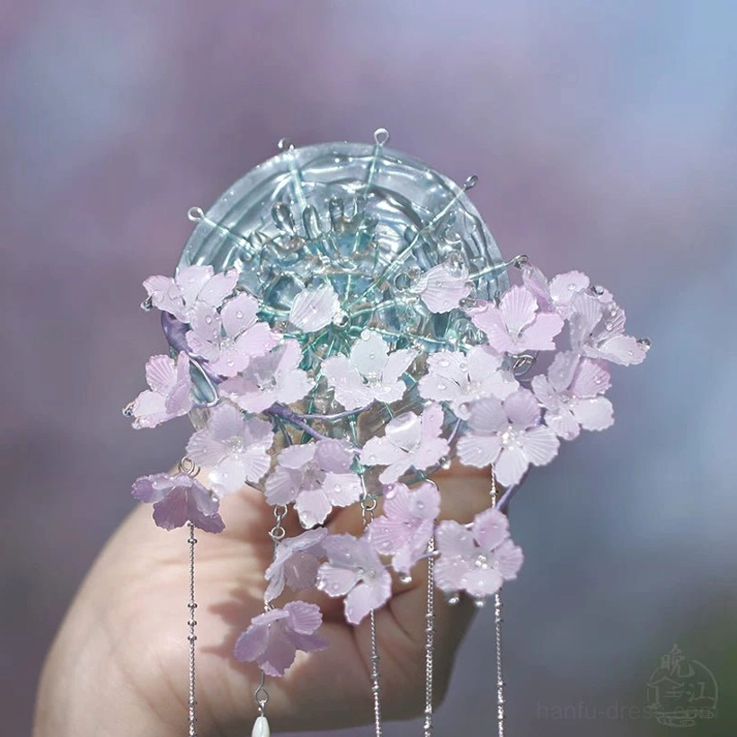 Elegant ancient Chinese cherry blossom hair stick shown from a low angle with dense gradient flowers long silver tassels and teardrop glass pendants