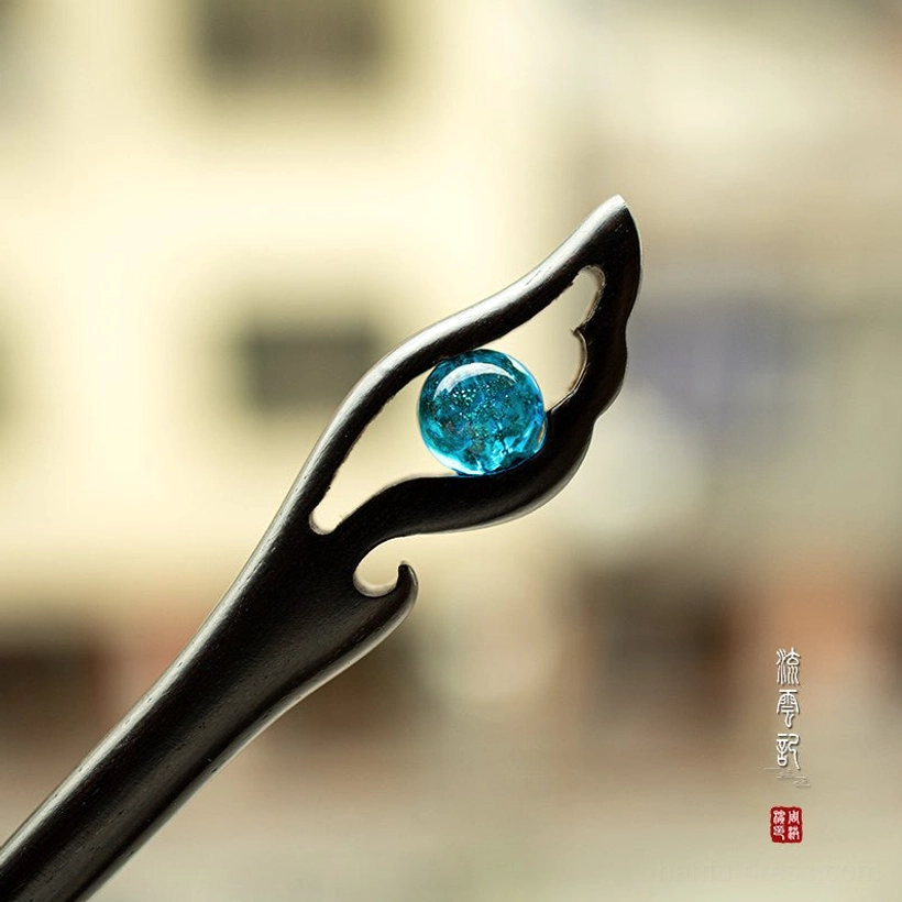 Blue crackle glass ancient Chinese ebony hair stick with carved hollow wing ornament close-up