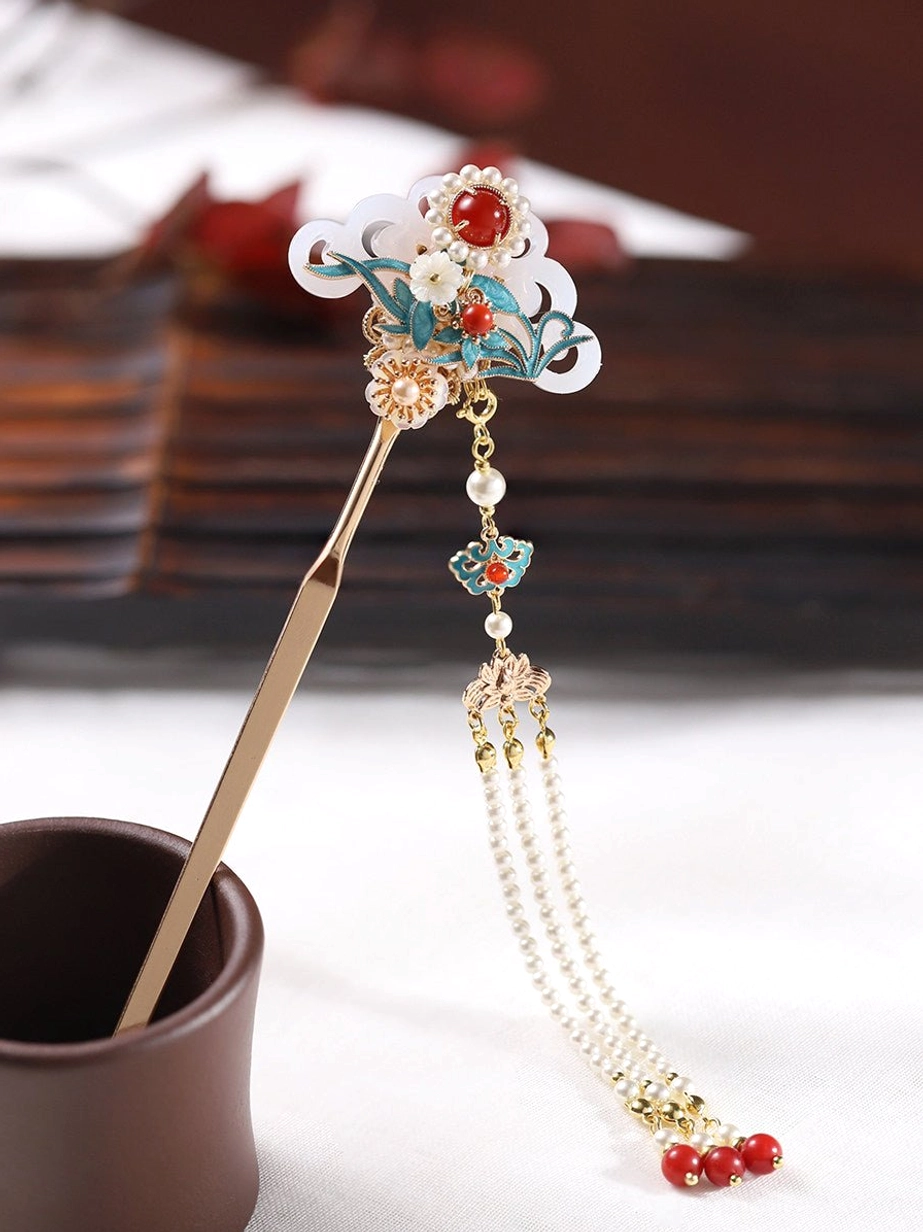 Side view of an ancient Chinese hair stick with blue cloisonne-style decoration, central red gem detail, layered chains, and long hanging tassel