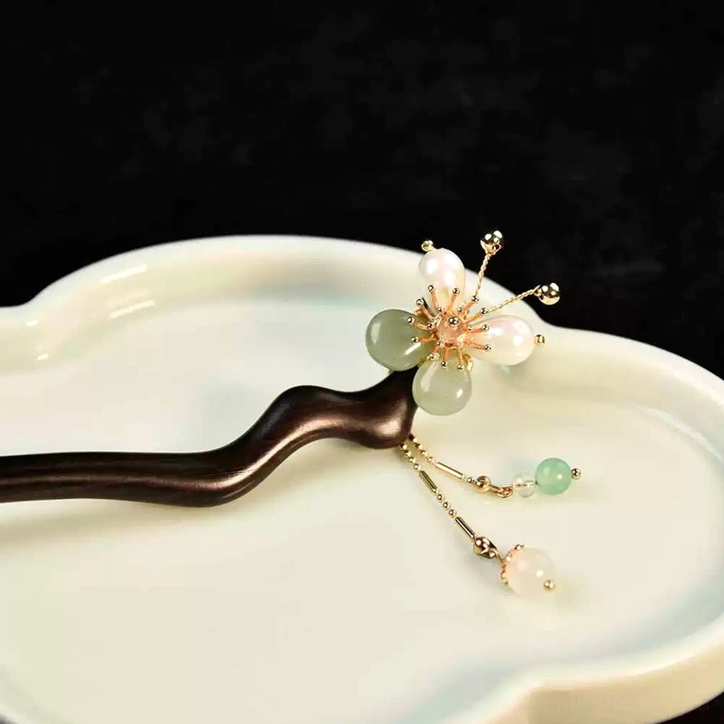 Ancient Chinese style plum blossom hairpin arranged on a cloud-shaped ceramic tray with a gold chain tassel and two small decorative pendants