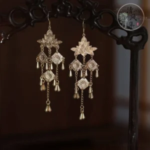 Antique gold lotus tassel Chinese earrings with clip-on closure displayed on carved dark wood furniture