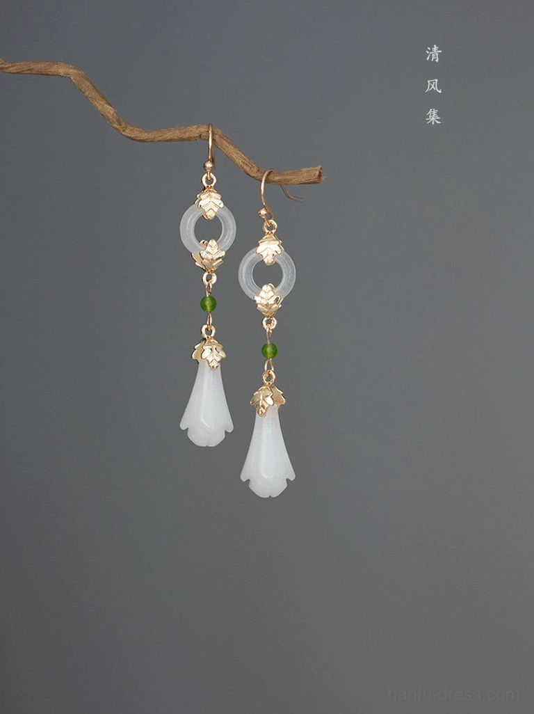 Antique magnolia Chinese earrings for Hanfu displayed on a natural twig with white flower drops jade-look round charms green beads and gold-toned details