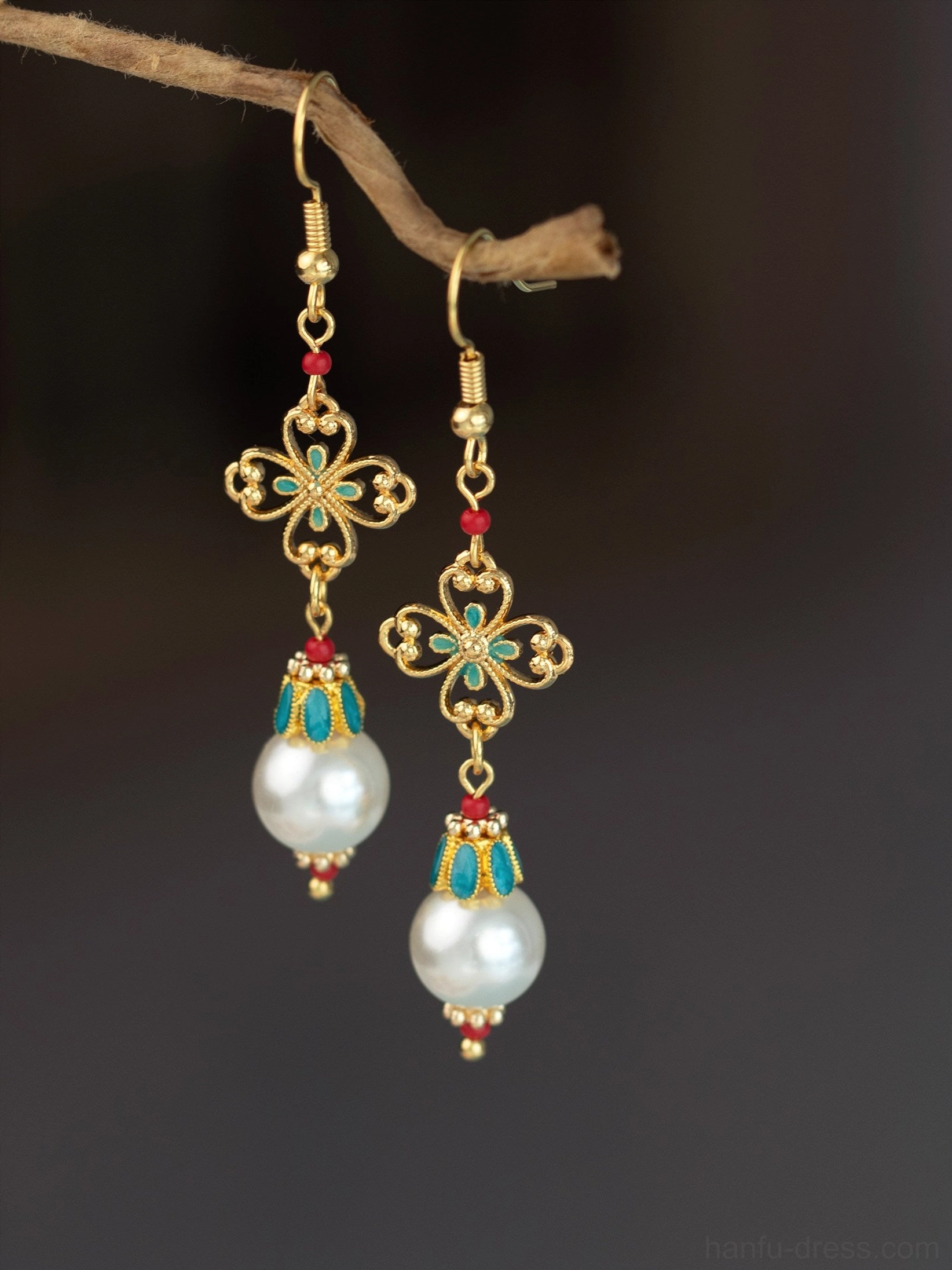Antique pearl dangle Chinese earrings with gold filigree four leaf charms turquoise accents red beads and white pearl pendants shown in a frontal close up
