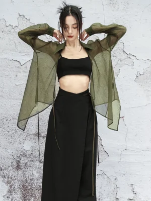 Army green modern Chinese style sheer cardigan with loose long sleeves, shirt collar, asymmetric hem, and dangling side tie straps worn with a black cropped camisole and long skirt