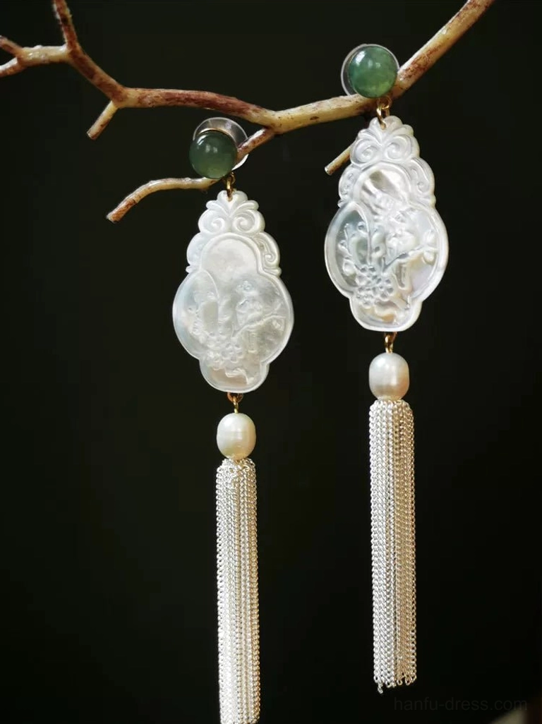 Asymmetric Hanfu tassel earrings with two different carved shell pendants, silver chains, pearls, and green jade accents