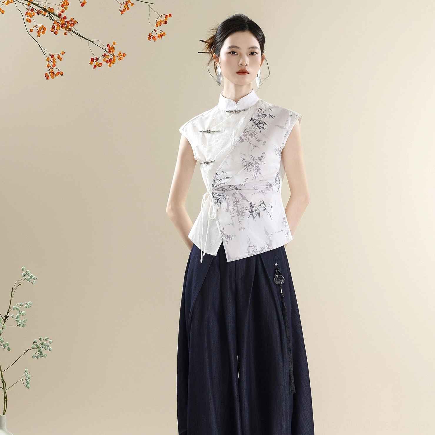 Side front view of asymmetric ink bamboo Mandarin collar sleeveless top with relaxed dark denim pants