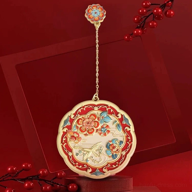 Auspicious Chinese pocket mirror with scalloped round gold-toned frame, colourful floral and bird motifs, red festive background, and matching flower pendant on a delicate chain