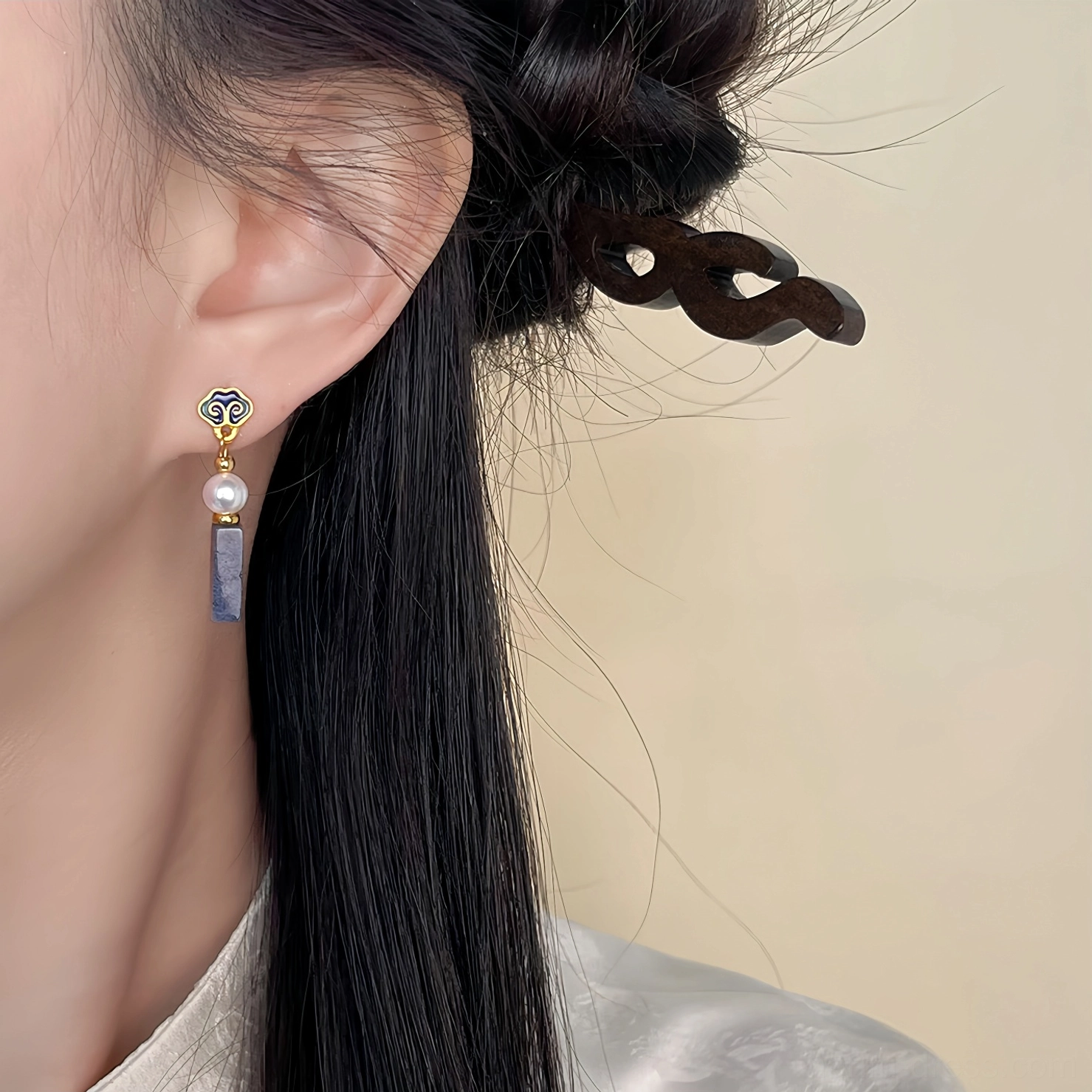 Elegant auspicious cloud drop earrings shown near the neck with gold cloud details, freshwater pearls, and gray-blue stone pendants