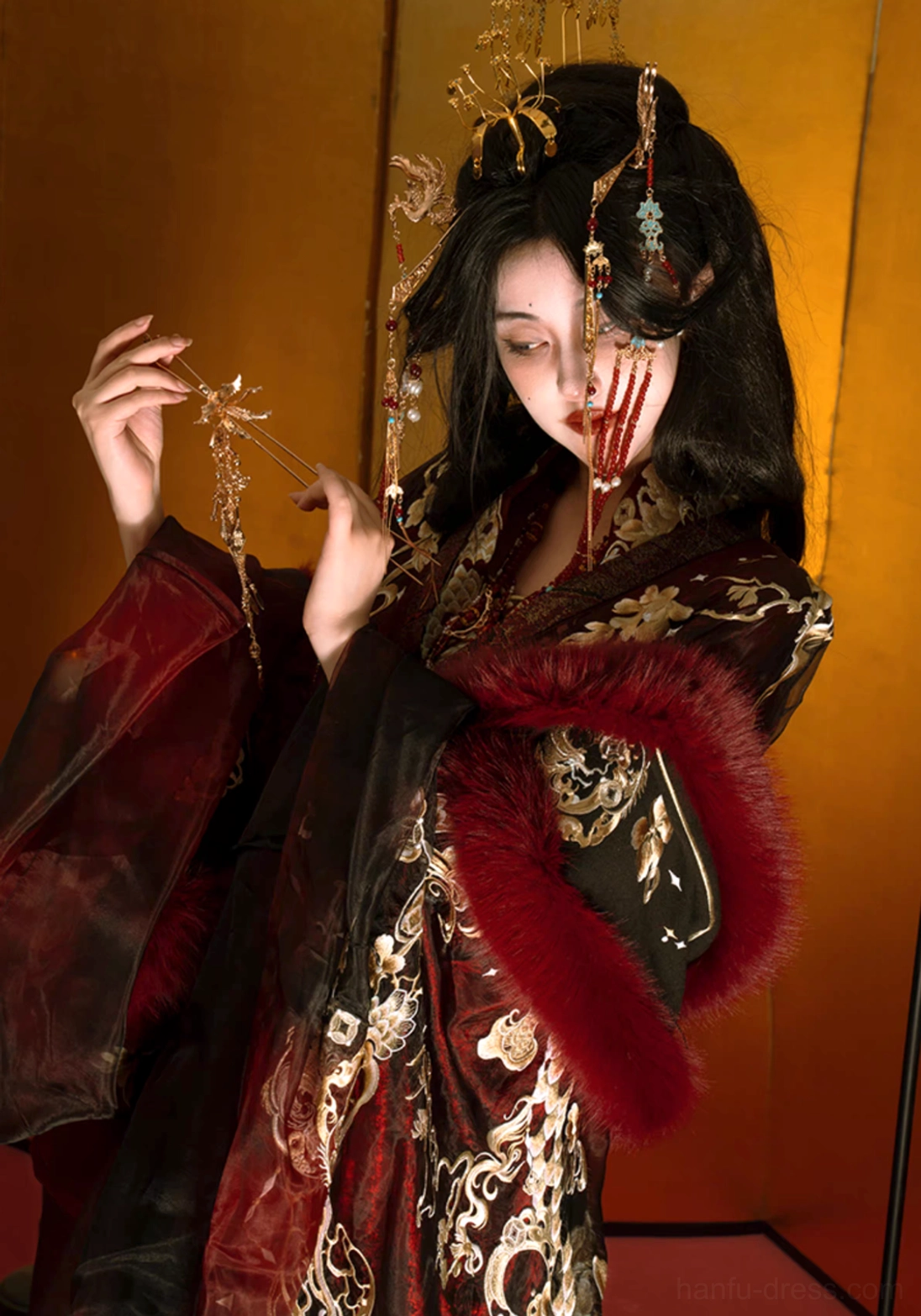 Close portrait of Autumn Dragon Hanfu with red faux fur cuffs intricate gold embroidery layered beaded necklaces and ornate hair ornaments
