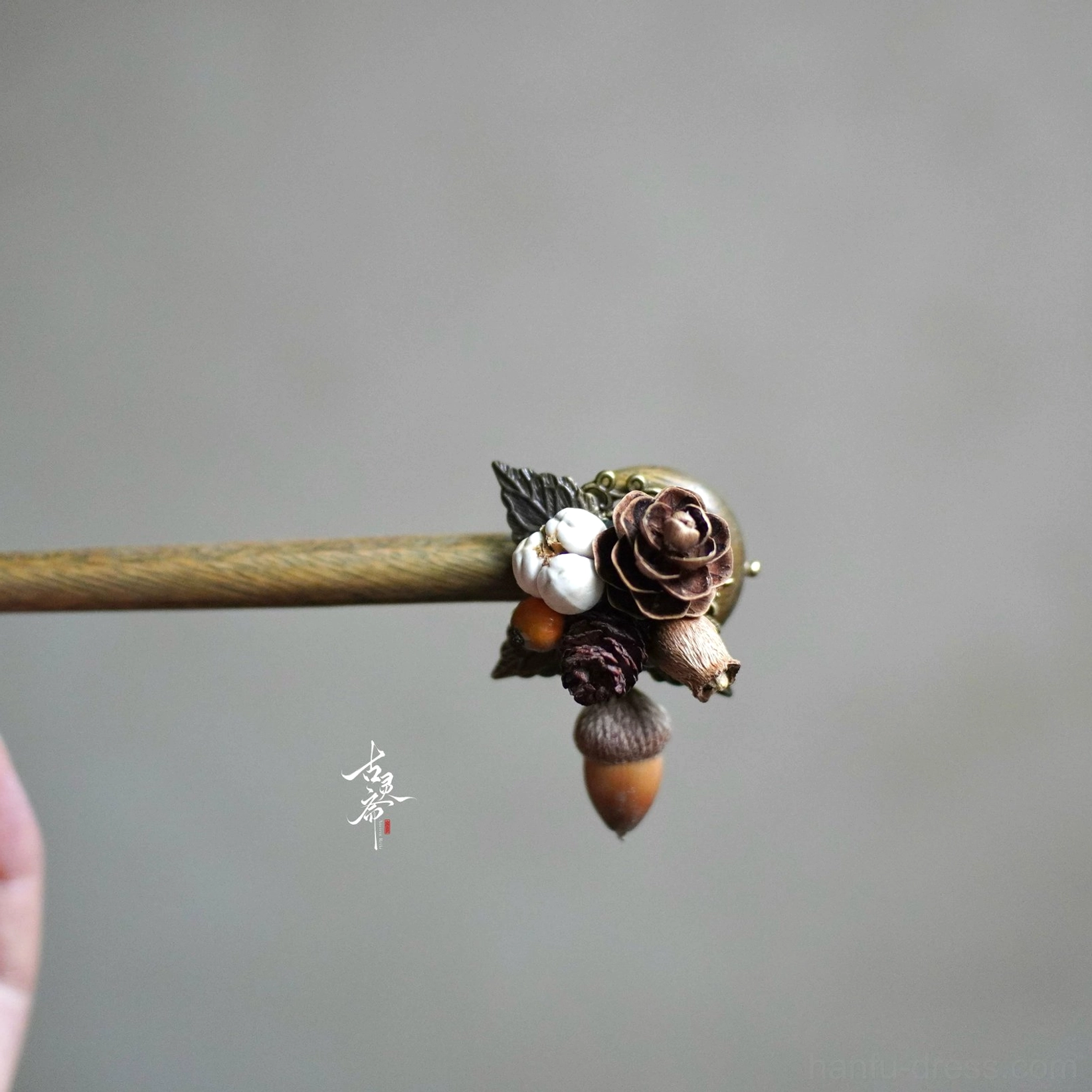 Close-up autumn forest pine wood Chinese hair stick with dried floral cotton pine cone and dangling acorn charm