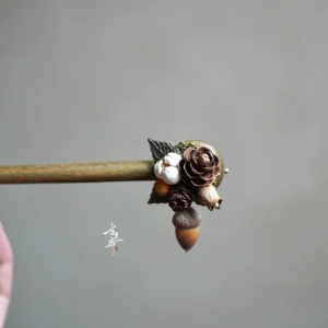 Close-up of handcrafted pine wood Chinese hair stick decorative head with dried flowers cotton and acorn pendant