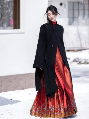 Black 100 percent wool Hanfu coat worn with a red and gold traditional mamian skirt in a snowy outdoor setting
