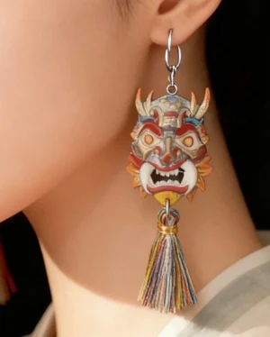 Close-up of a woman wearing an azure lion mask tassel earring with silver hook hardware and long multicolor tassel pendant