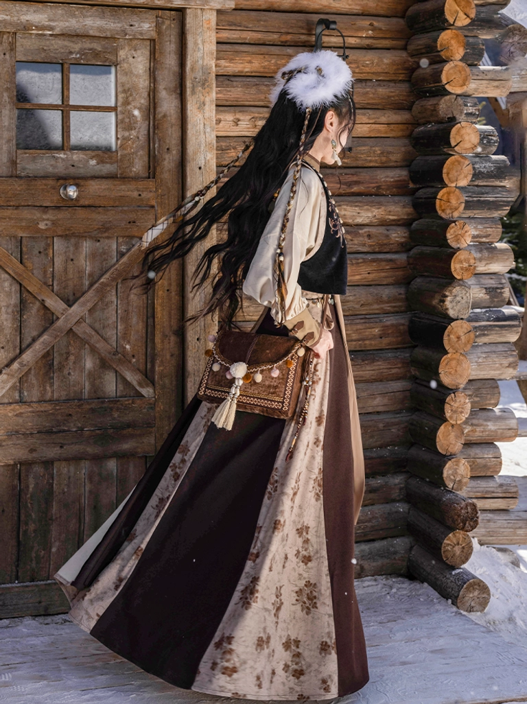 Back view of a Tang Dynasty-inspired Hanfu ensemble showing the cropped embroidered vest and flowing color-blocked wrap skirt with a woven bag