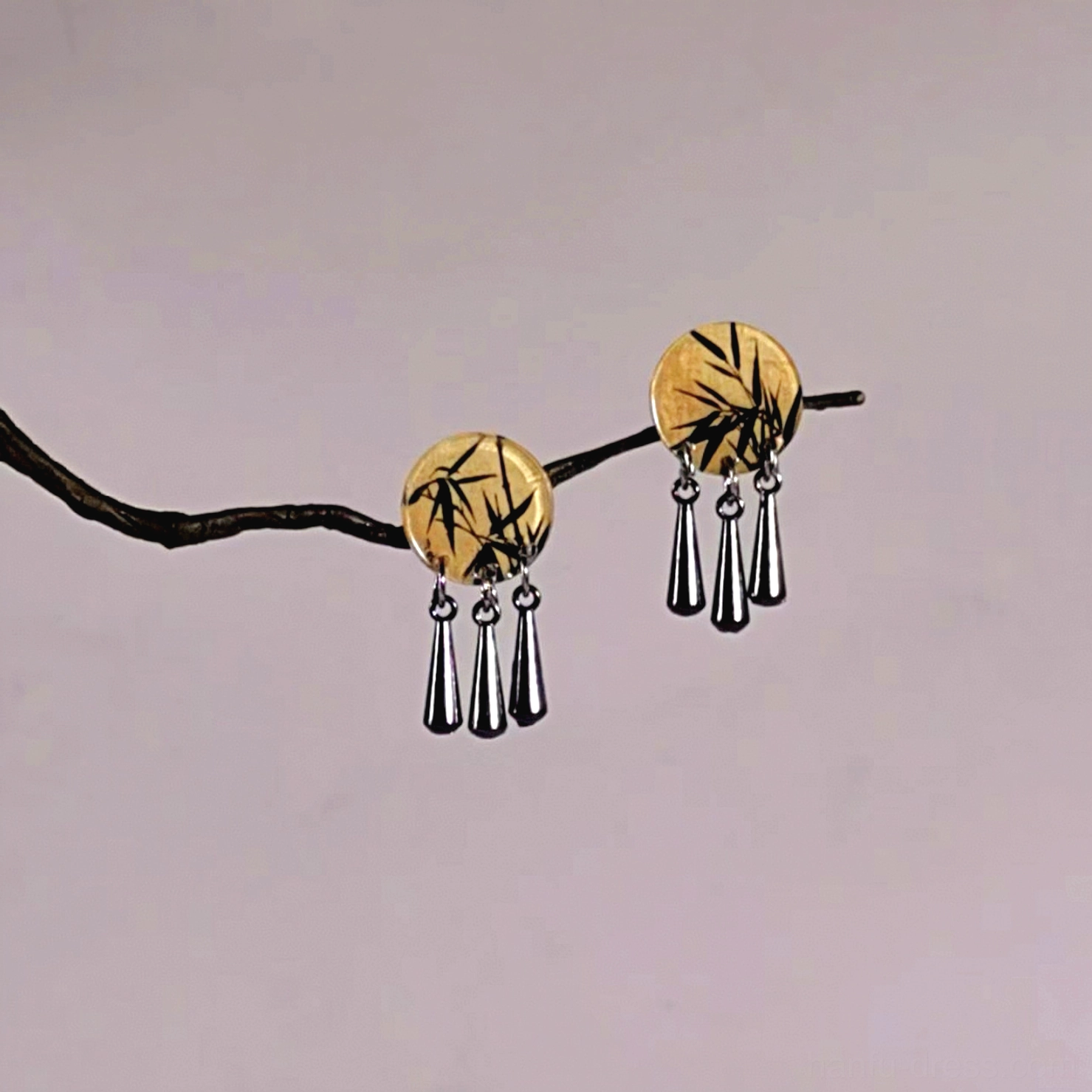 Bamboo Chinese dangle earrings for Cheongsam featuring round yellow wood-toned charms with black ink bamboo artwork and three silver teardrop pendants