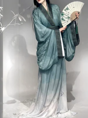 Cyan gradient Han Dynasty straight hem hanfu robe with dark green trim and wide flowing sleeves shown in a bamboo studio setting