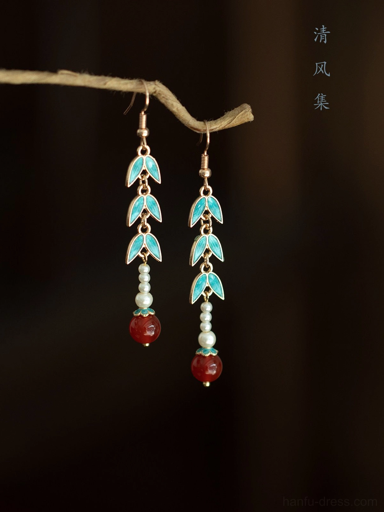 Bamboo pearl and red agate Chinese Hanfu drop earrings displayed on a natural twig against a dark background