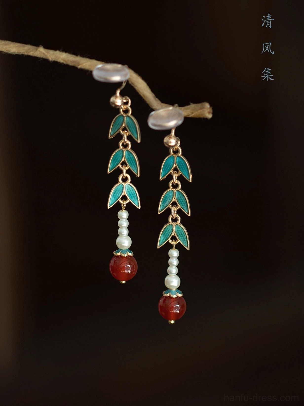 Traditional Chinese bamboo earrings featuring blue green leaf charms large white pearl detail and red dangling bead accents