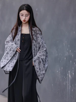 Front full-body view of a light gray bamboo printed modern Hanfu cardigan with reddish leaves, wide sleeves, cross collar, and side waist ties styled with black trousers