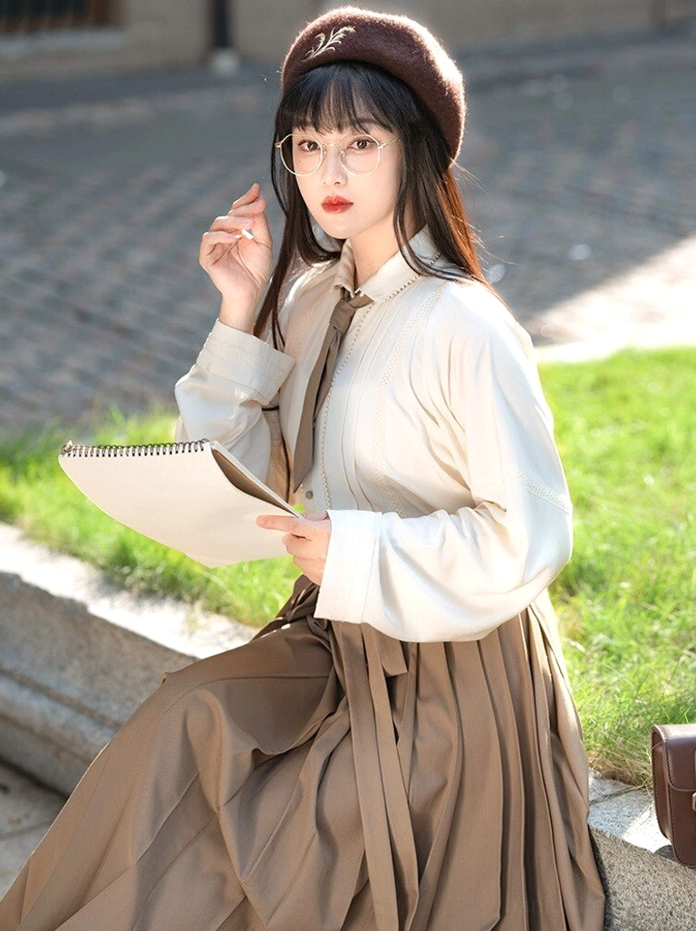 Beige Ming Dynasty inspired Hanfu pintuck shirt with wide sleeves and tan pleated skirt in an outdoor scholarly outfit