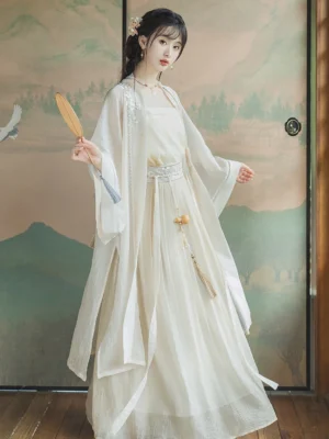 Beige Song Dynasty Hanfu complete set shown from the front three-quarter view with embroidered beizi collar, flowing long skirt, Chinese landscape screen, and handheld folding fan