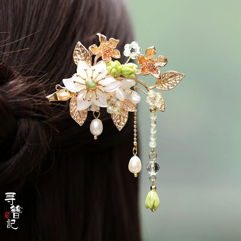 Biluo white flower tassel Hanfu hairpin worn in black hair showing gold toned ornaments green accents and double dangling bead chains