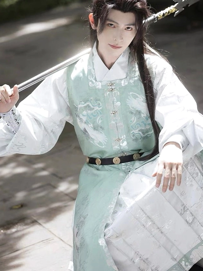 Low angle view of men's jade green and white Ming Dynasty hanfu showing detailed crane embroidery and layered wuxia robe styling