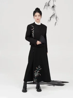 Full-body front view of a black modern Hanfu two-piece outfit with bamboo embroidery, cropped robe jacket, flowing A-line skirt, white inner collar, and black boots