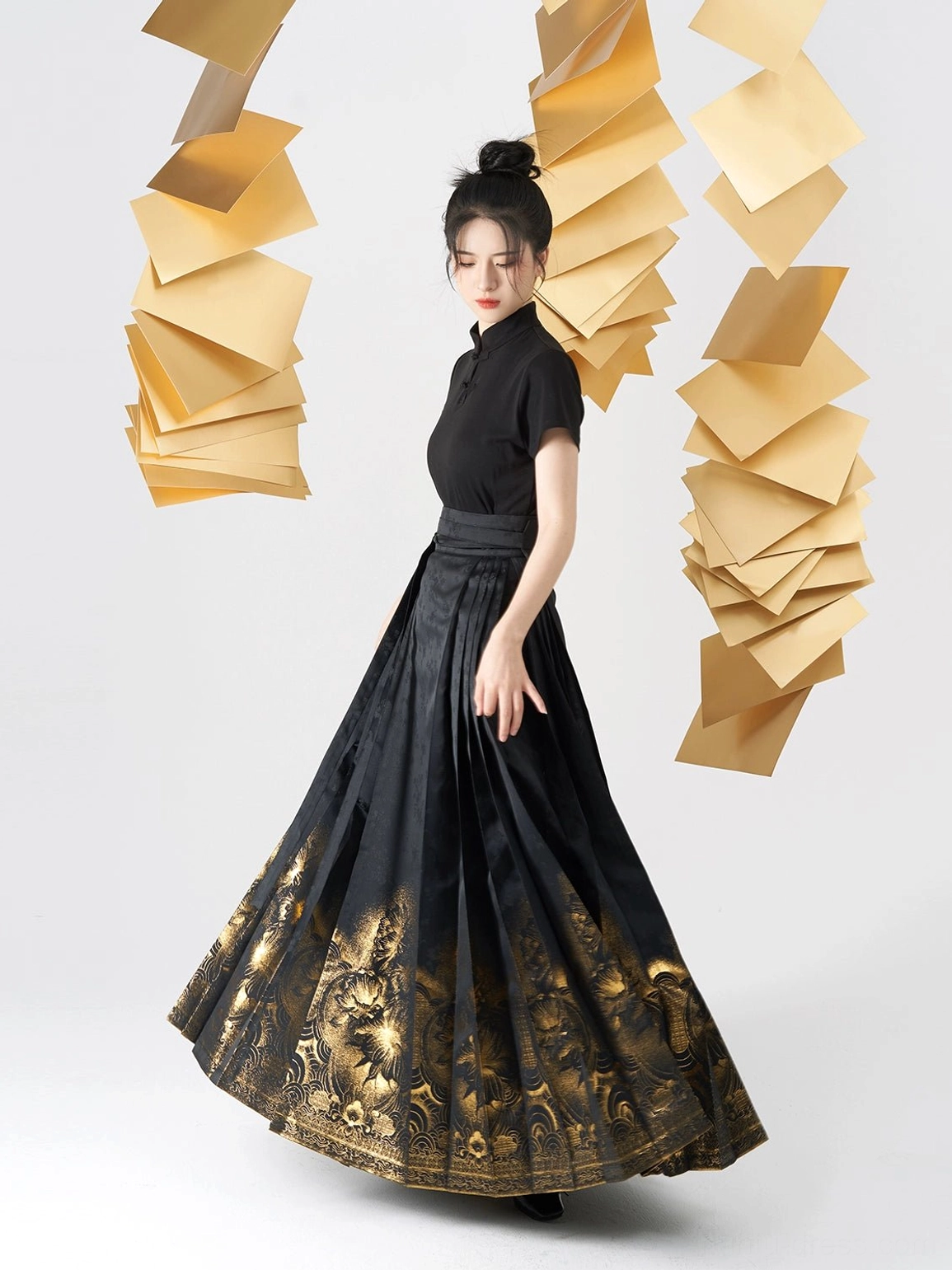 Side full-body view of a black Chinese blouse and structured mamian skirt with dark jacquard fabric and golden floral hem