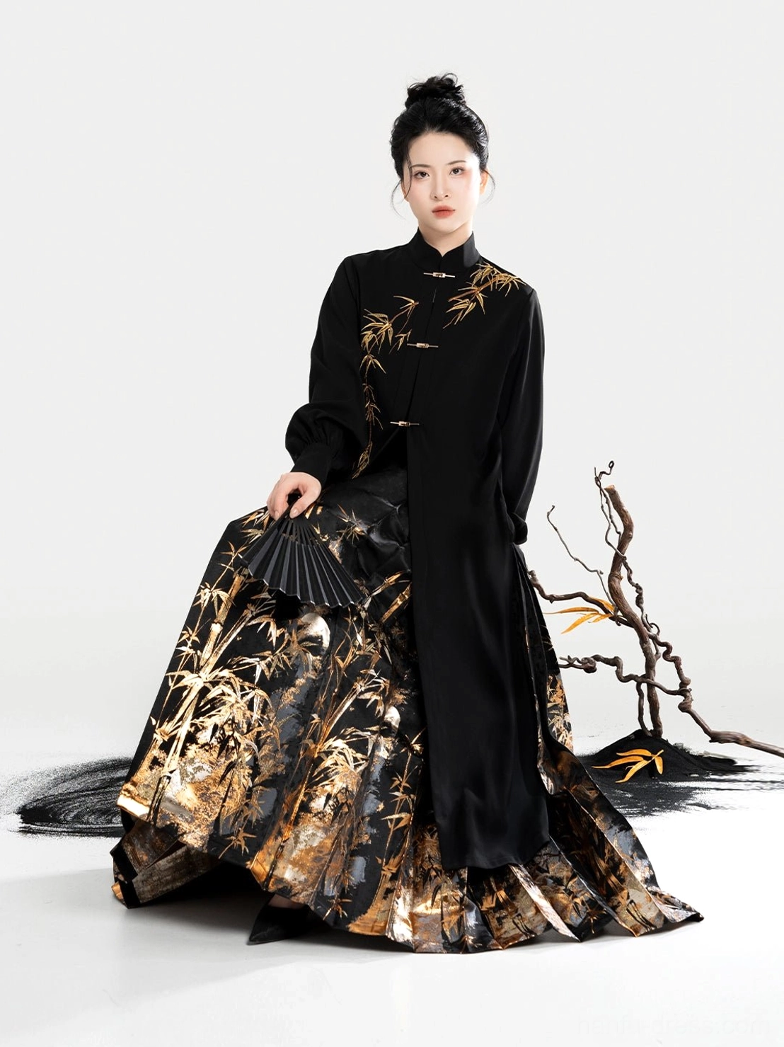 Front view of a black Chinese blouse and matching pleated mamian skirt with golden bamboo motifs