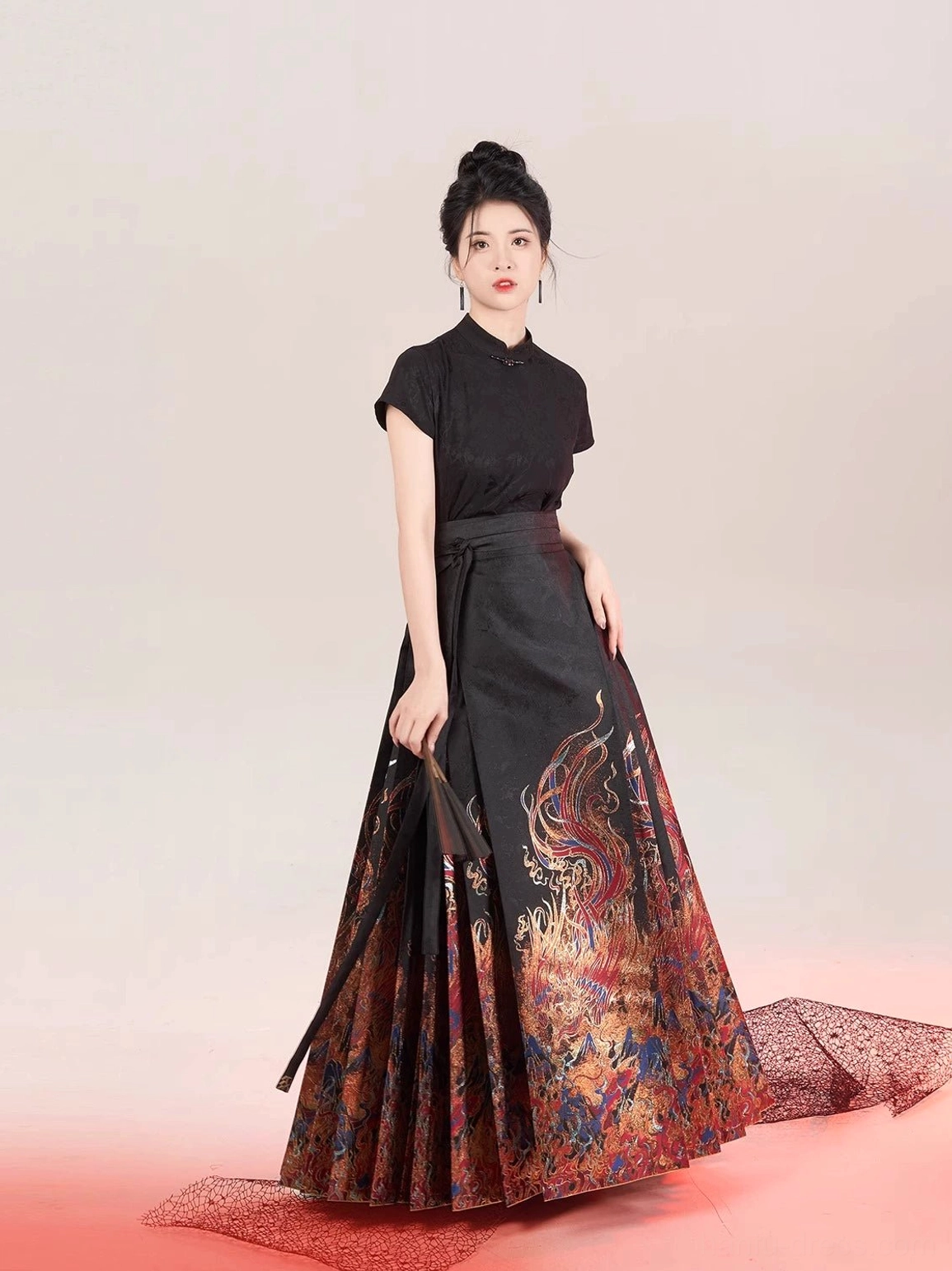 Front three-quarter view of a black stand-collar Chinese blouse with a full-length pleated mamian hanfu skirt