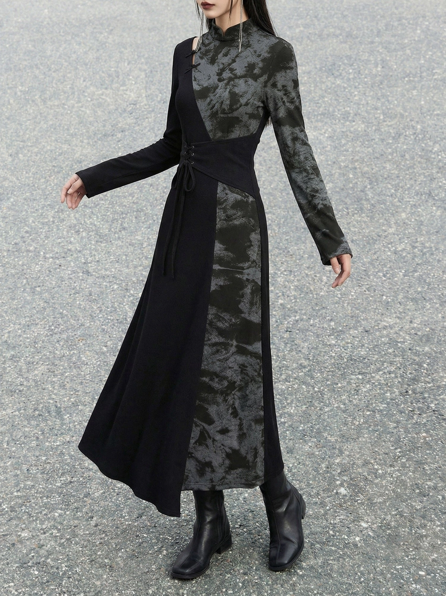 Side front view of a black Chinese-style contrast panel maxi dress with fitted long sleeves, asymmetric fabric splicing, stand collar, and floor-length silhouette
