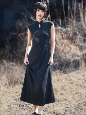 Black Chinese-style modern Hanfu dress with a flowing floor-length skirt and textured jacquard appearance, shown as the model lifts the hem in an outdoor grassland setting