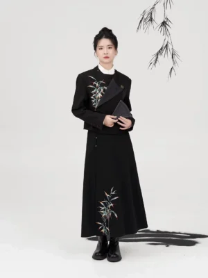 Three-quarter front view of a black Chinese style Hanfu jacket and embroidered A-line skirt outfit with matching bamboo details and black clutch