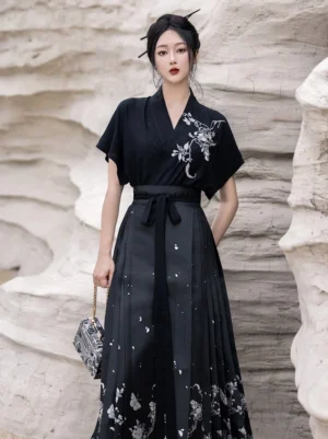Three-quarter view of a black Chinese-style Hanfu top and pleated Mamianqun skirt with silver embroidery and waist sash