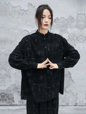 Full-body view of a woman wearing a black Chinese-style oversized Hanfu shirt with stand collar bishop sleeves and hidden button front