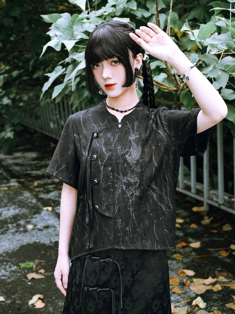 Young woman wearing a black modern Hanfu short sleeve shirt with stand collar, asymmetrical frog closure, crane embroidery, and textured jacquard fabric