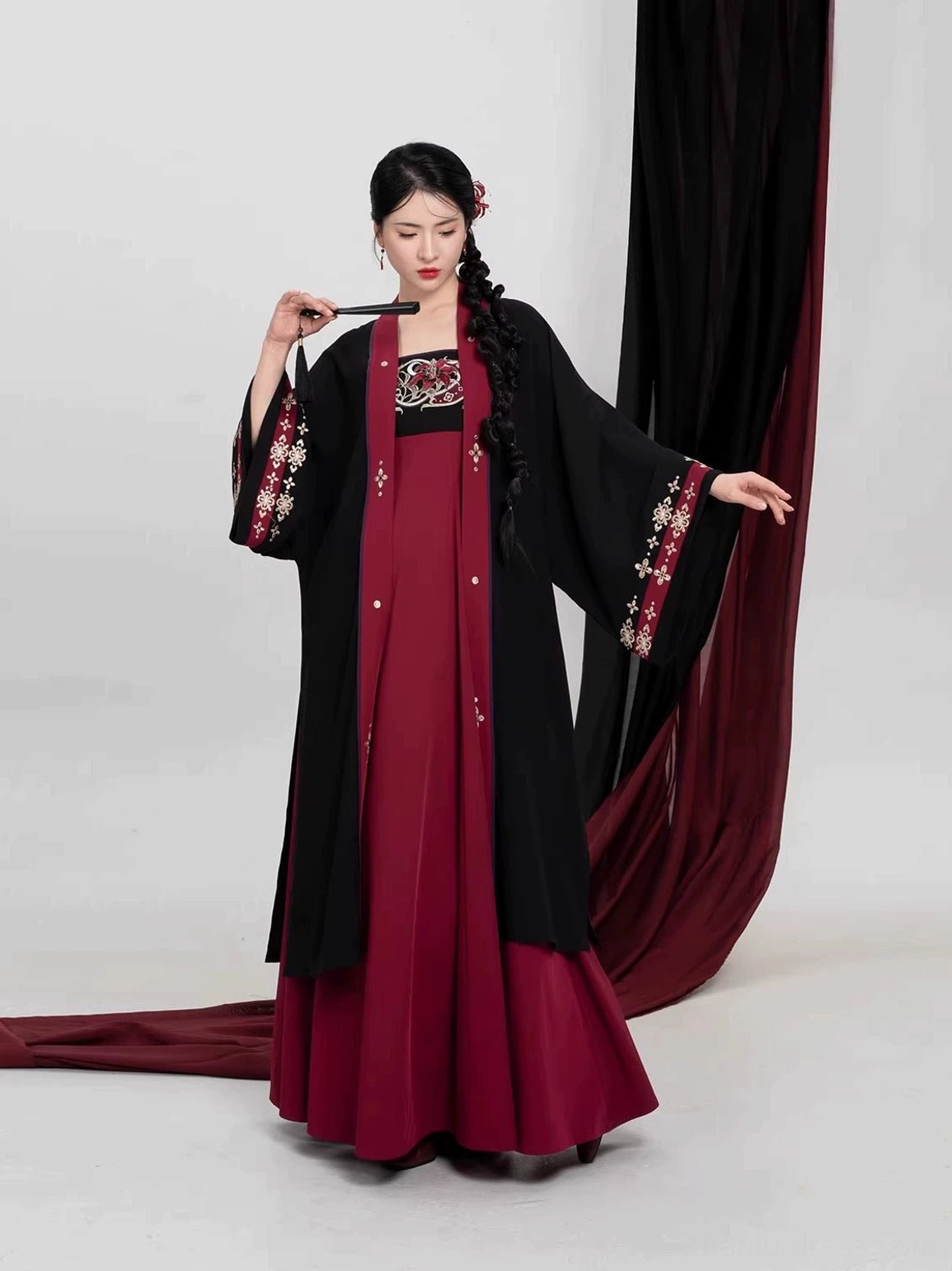 Elegant front view of a black and crimson modern Hanfu outfit with embroidered dress bodice, long Beizi jacket, and traditional Chinese hair accessory styling
