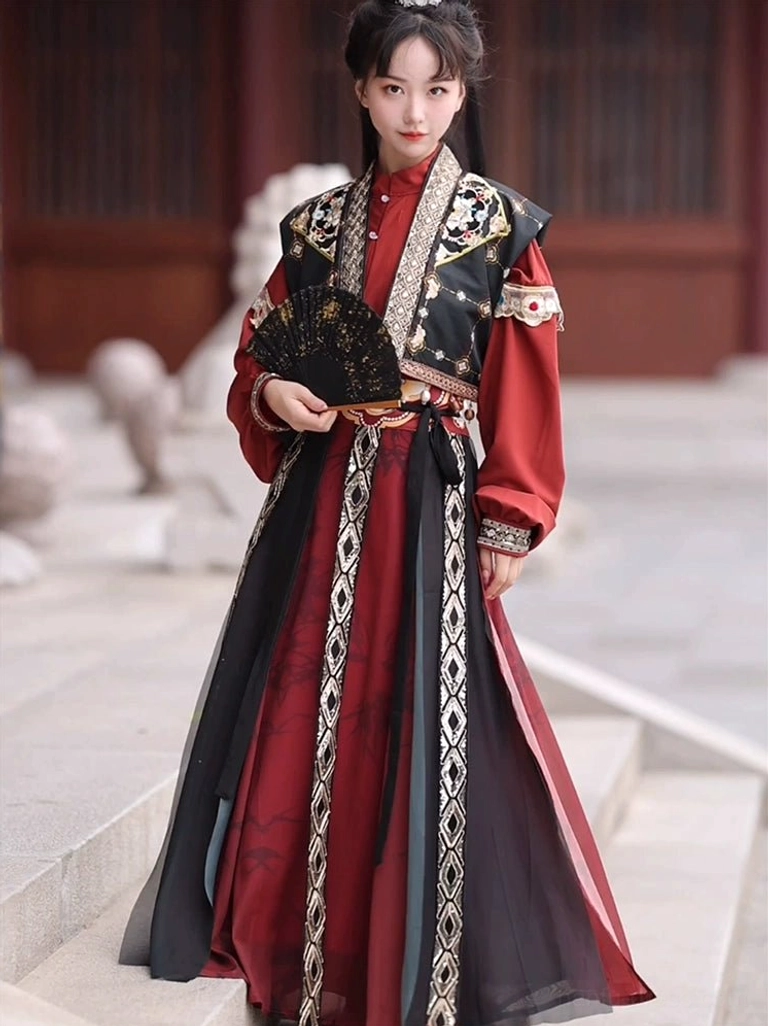 Black embroidered vest with red inner shirt and flowing wrap skirt styled as a Tang Dynasty hanfu swordsman costume with folding fan