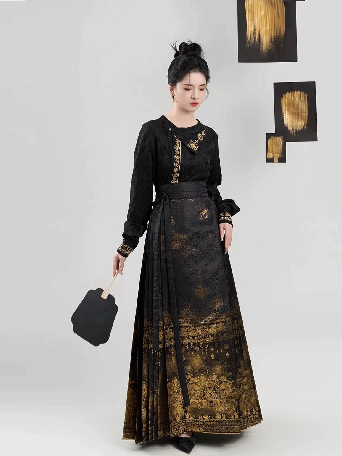 Black and gold Ming Dynasty Hanfu outfit with waist-cinching mamianqun skirt and elaborate traditional gilt decorative patterns along the lower hem