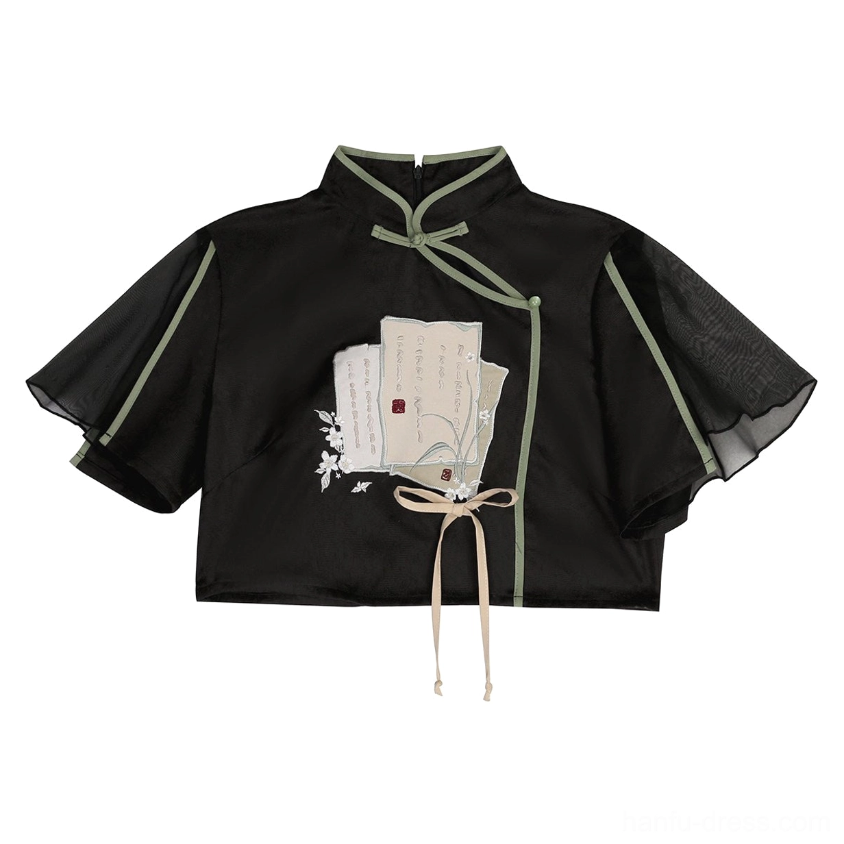 Close-up flat lay of black satin Hanfu cropped top with green piping sheer sleeves and vintage book embroidery pattern