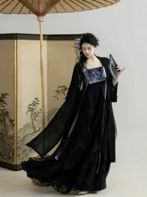 Three-quarter view of black Hanfu dress with sheer outer robe, purple embroidered chest panel, flowing skirt train, and traditional Chinese fan styling