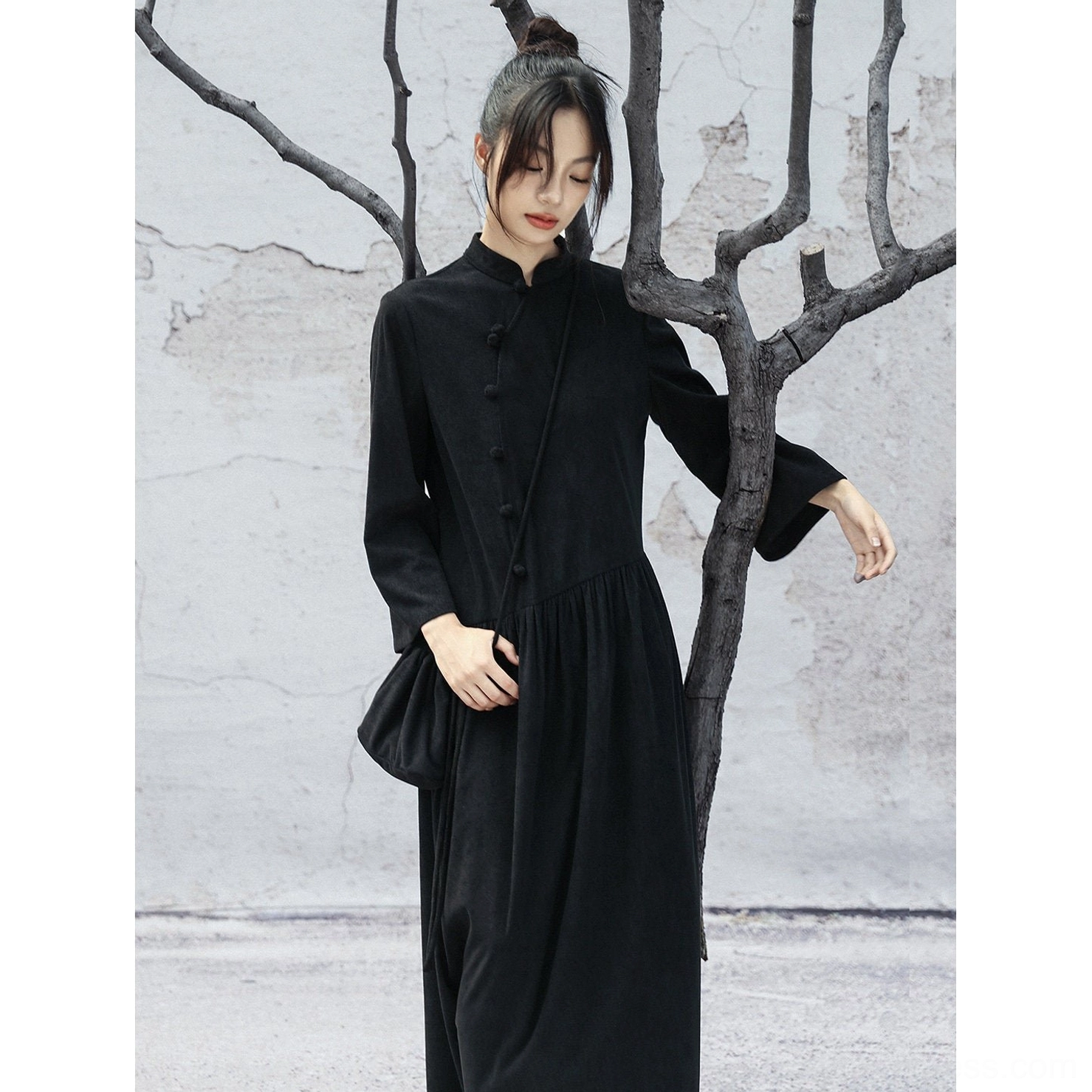 Half-body side view of a minimalist black long-sleeve Chinese-style dress with soft corduroy-look texture and relaxed casual silhouette