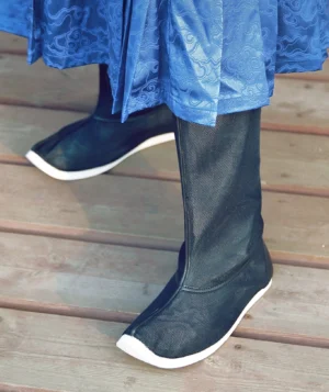 Side wearing view of breathable black Chinese Hanfu boots paired with a blue cloud-patterned Hanfu garment on an outdoor wooden deck