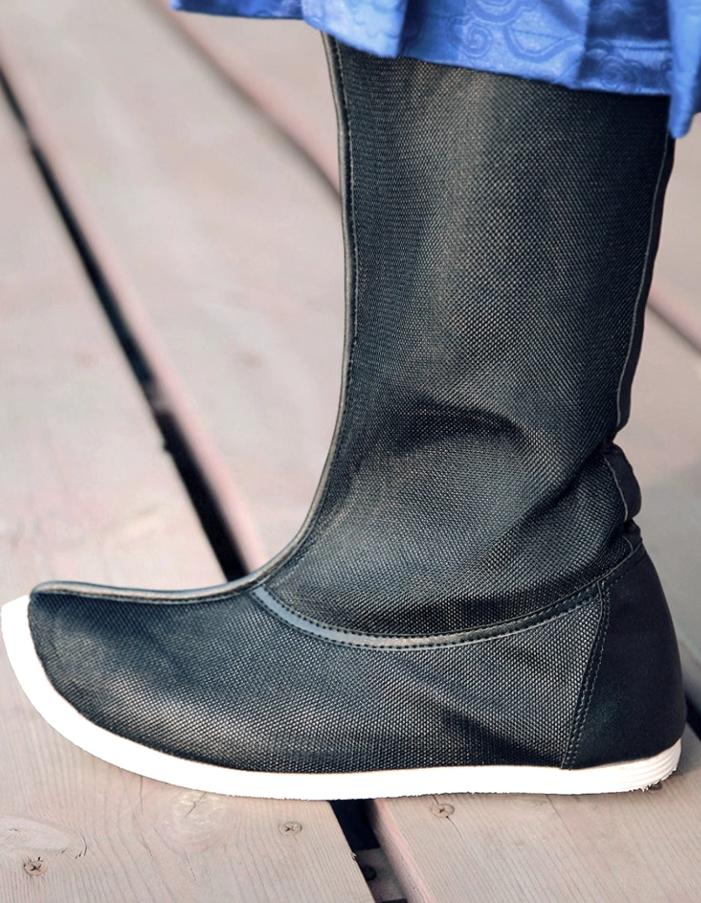 Close-up rear side view of black mesh Hanfu boots showing textile texture, neat heel stitching, reinforced upturned toe, and white rubber outsole
