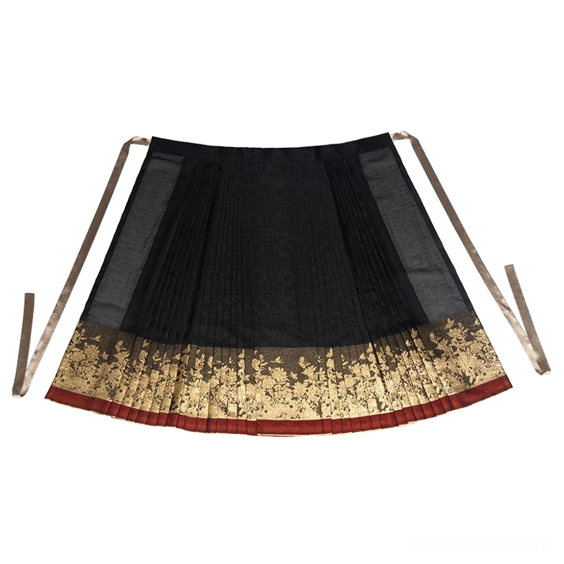 Flat lay of a black Ming Dynasty Hanfu mamianqun skirt showing structured pleats, decorative gilded peony hem, red bottom trim, and long waist straps