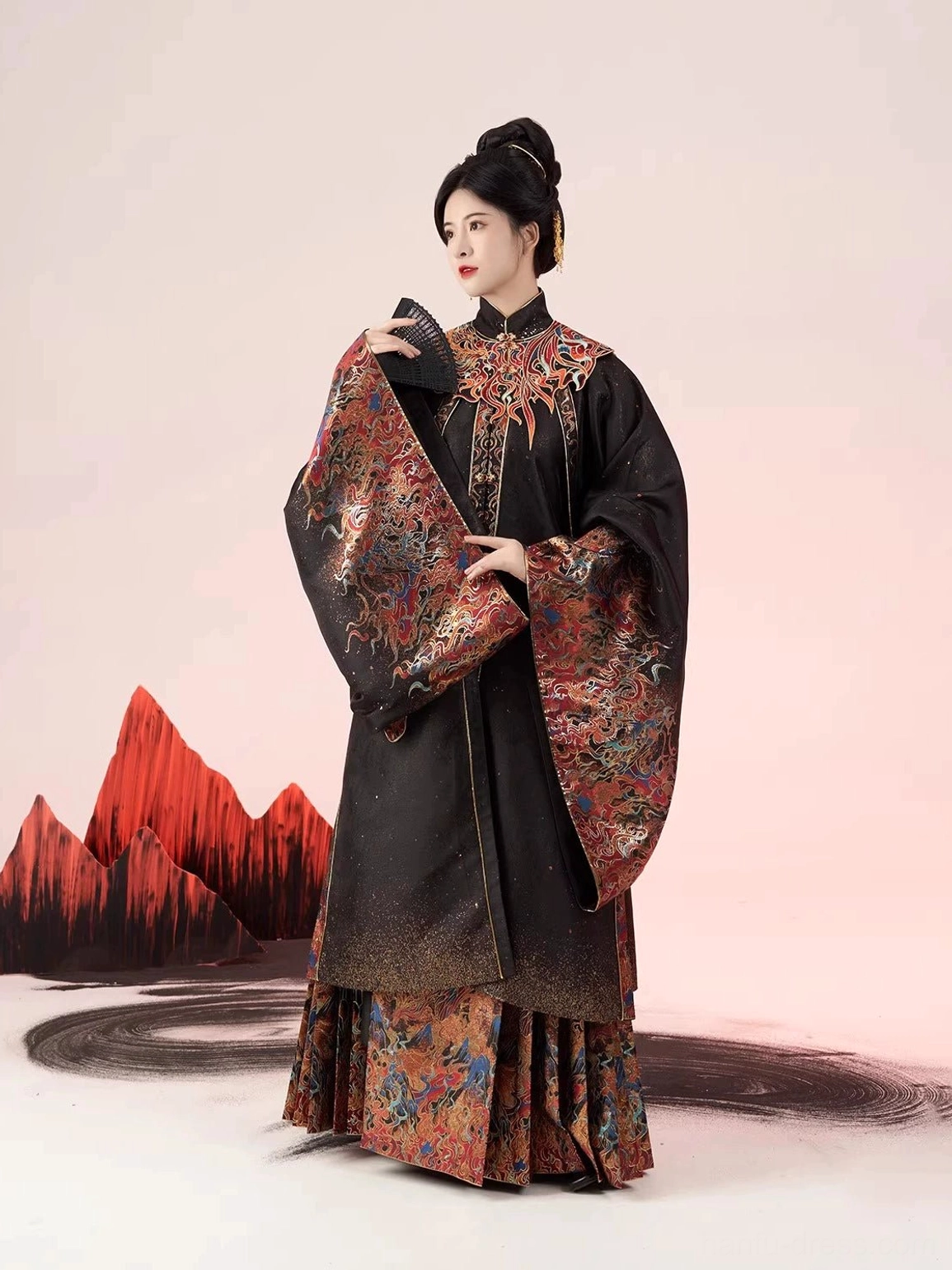 Three-quarter view of a black Ming Dynasty Hanfu robe and mamian skirt with warm crimson embroidery on the collar, cuffs, and skirt hem
