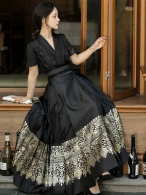 Side view of black Ming Dynasty inspired Hanfu mamianqun with flowing floor-length skirt, gold patterned hem, and elegant lace-trimmed top