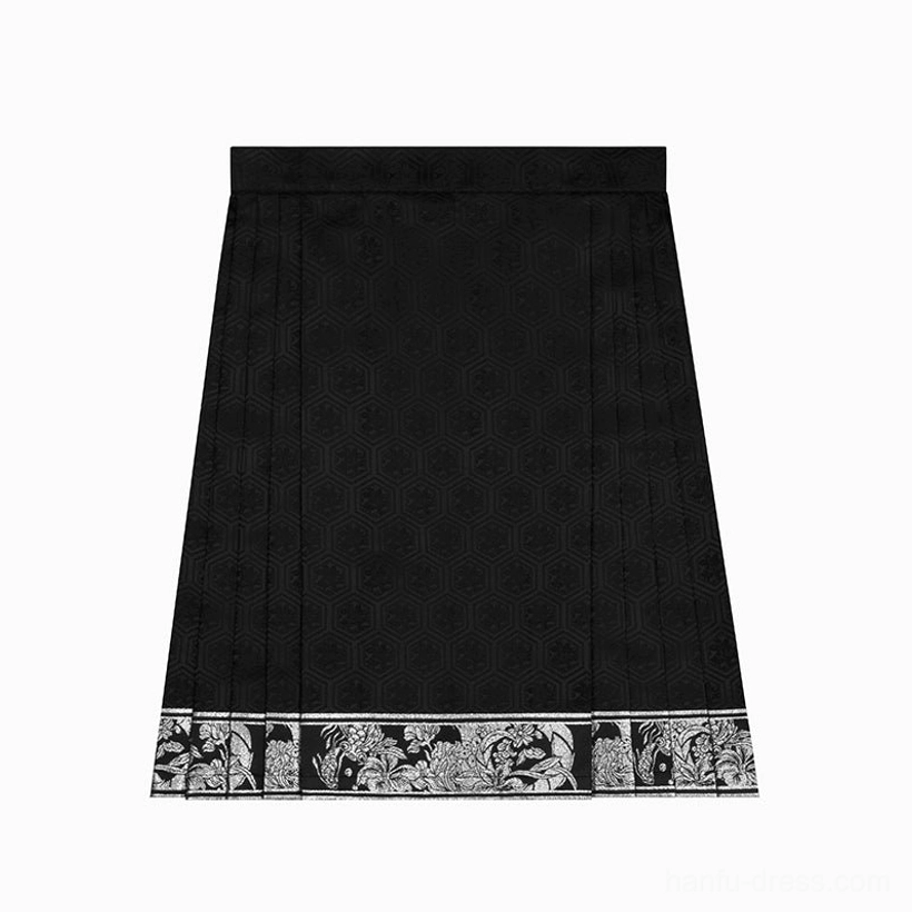 Flat lay of the black high-waisted mini mamian skirt showing its pleated shape, subtle geometric jacquard, and silver-black patterned hem